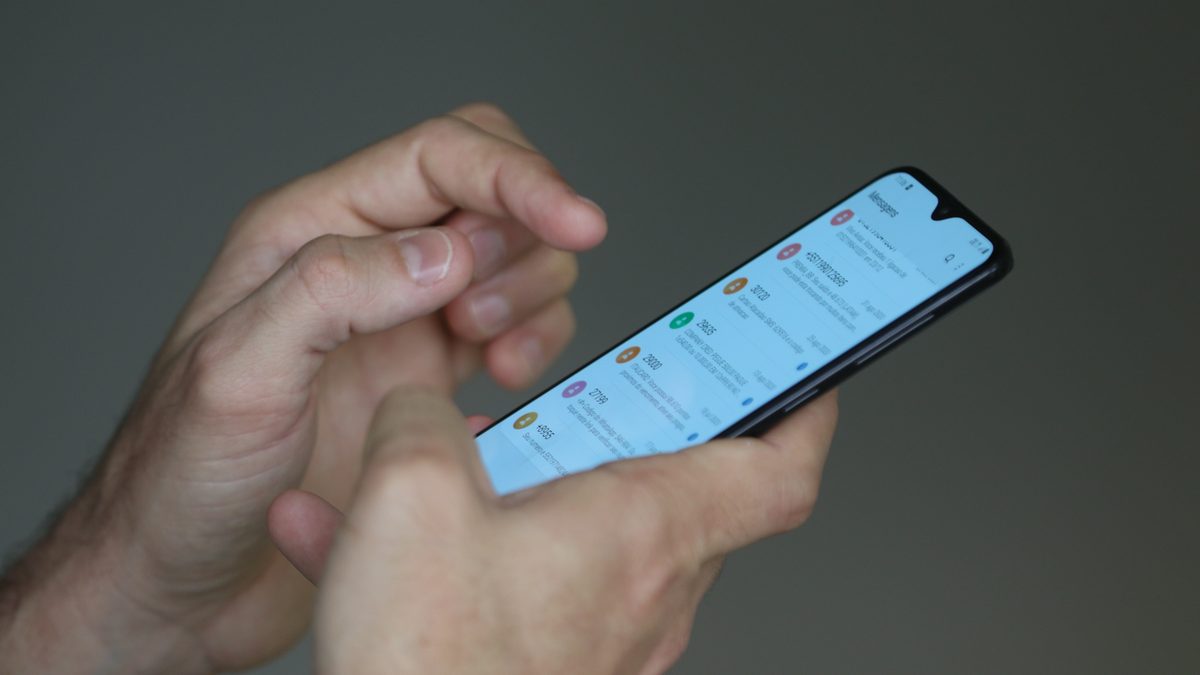 Duas mãos seguram um celular com a lista de mensagens aberta na tela, em foto de arquivo da Agência Brasil