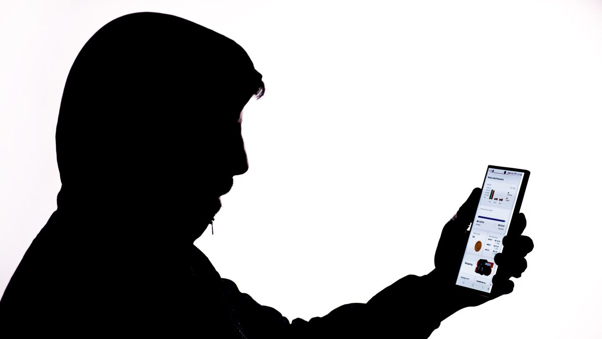 Silhueta de homem mexendo em aplicativo no celular