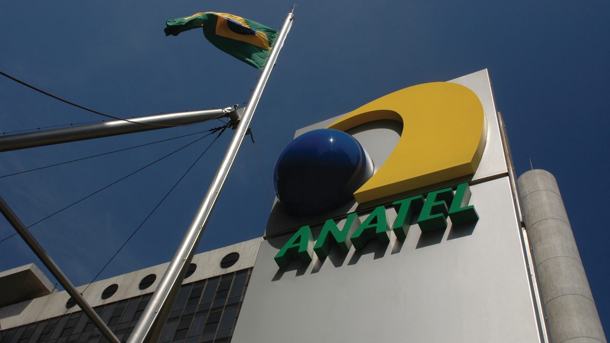 Totem com o logotipo da Anatel e a bandeira do Brasil diante da sede da agência, em Brasília