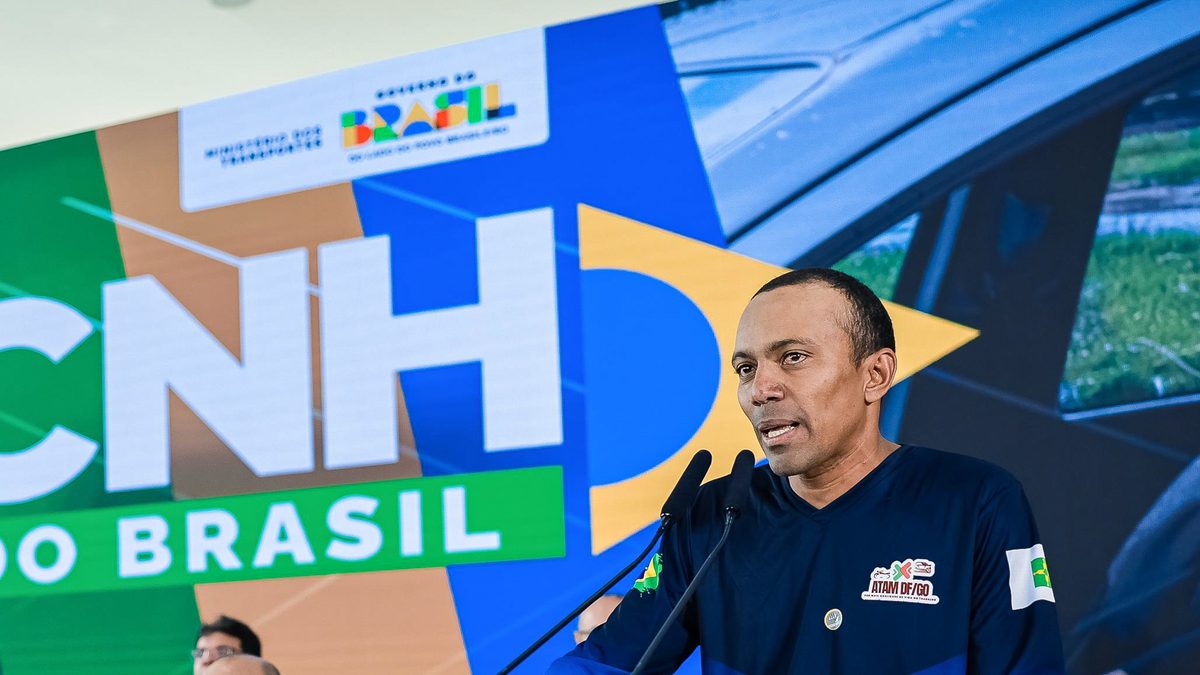 Homem de camisa azul discursa ao microfone diante do painel da cerimônia de anúncio do CNH do Brasil, no Palácio do Planalto, em Brasília