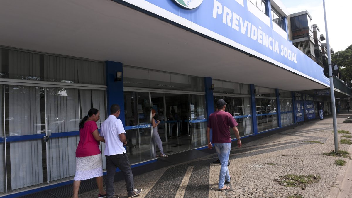 Segurados caminham até a entrada de uma agência da Previdência Social em Brasília, em fevereiro de 2019