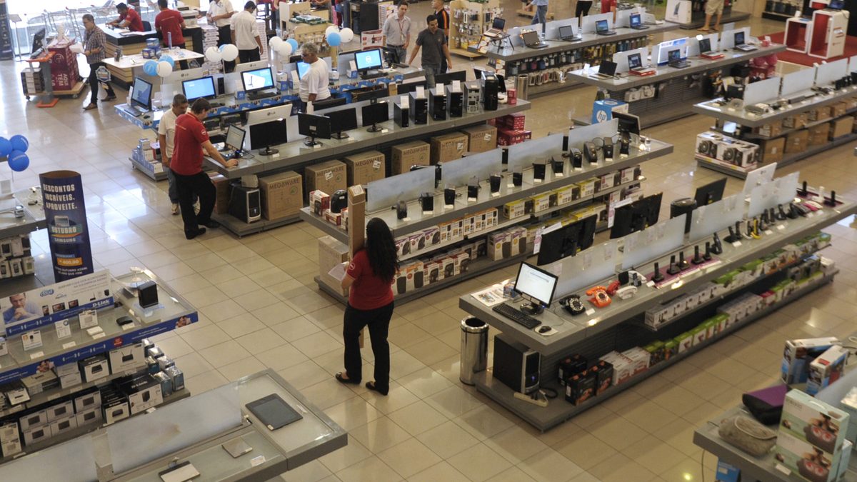Clientes e vendedores circulam entre bancadas de computadores e eletrônicos numa loja de informática em Brasília