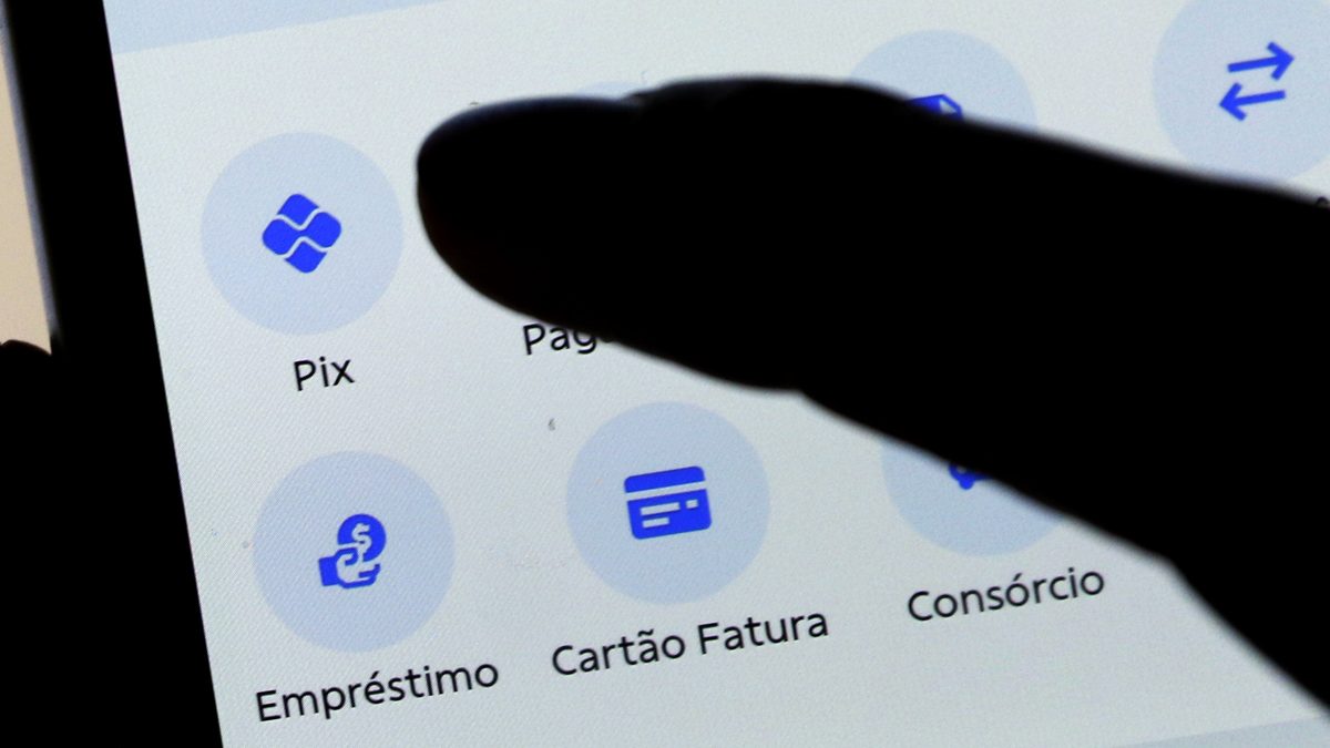 Dedo toca o botão Pix na tela de um aplicativo de banco, em foto de arquivo