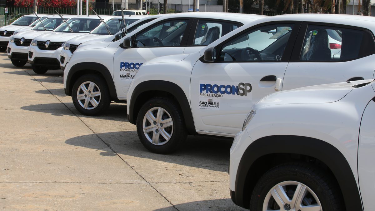 Carros brancos de fiscalização do Procon-SP enfileirados, com o logotipo do órgão e do Governo de São Paulo na porta
