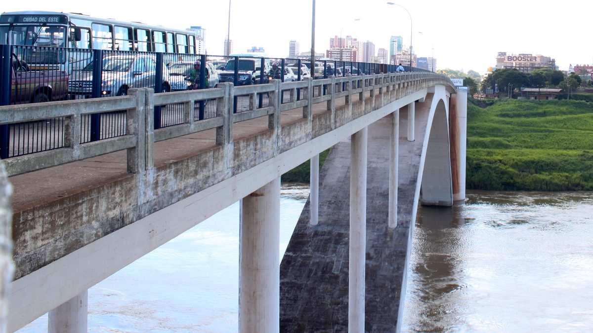 Ponte da Amizade, entre Foz do Iguaçu e Ciudad del Este, com ônibus e carros na pista e o rio Paraná embaixo