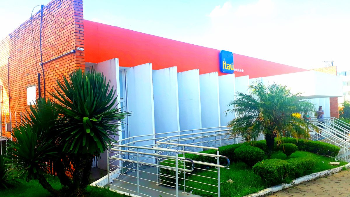 Fachada de uma agência do Itaú com placa azul e amarela