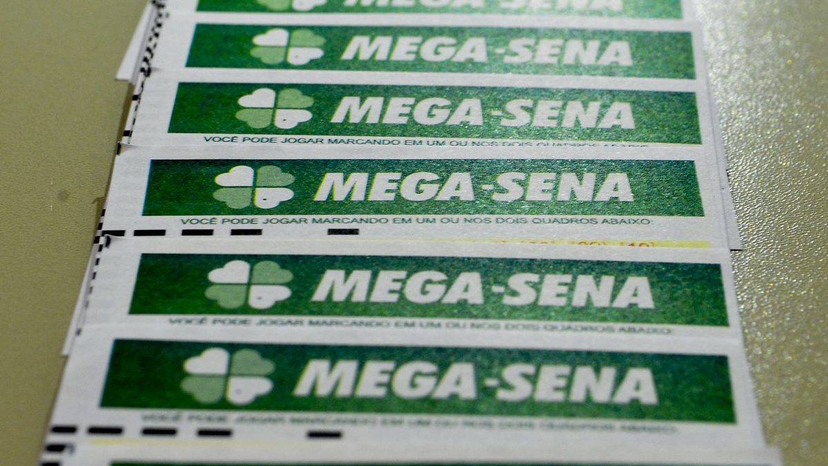 Volantes da Mega-Sena empilhados sobre uma mesa