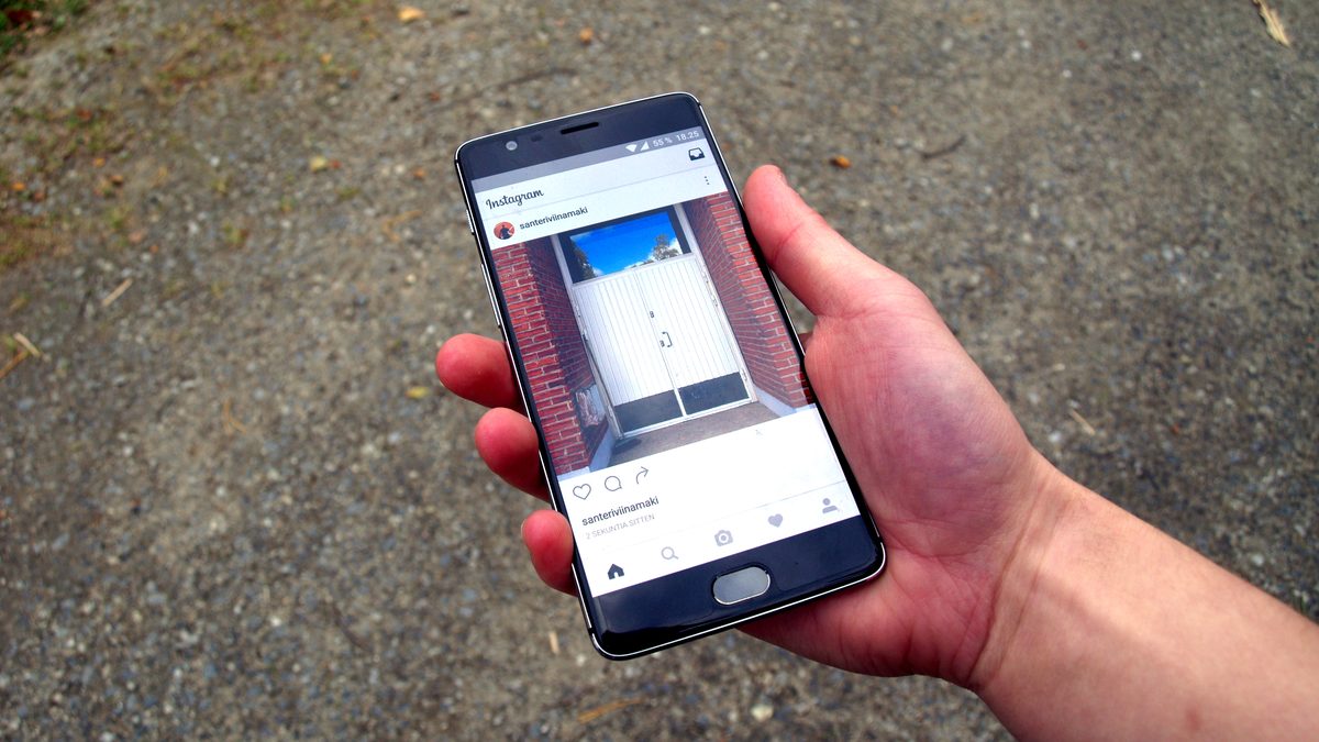 Mão segura um celular com um perfil aberto no aplicativo do Instagram