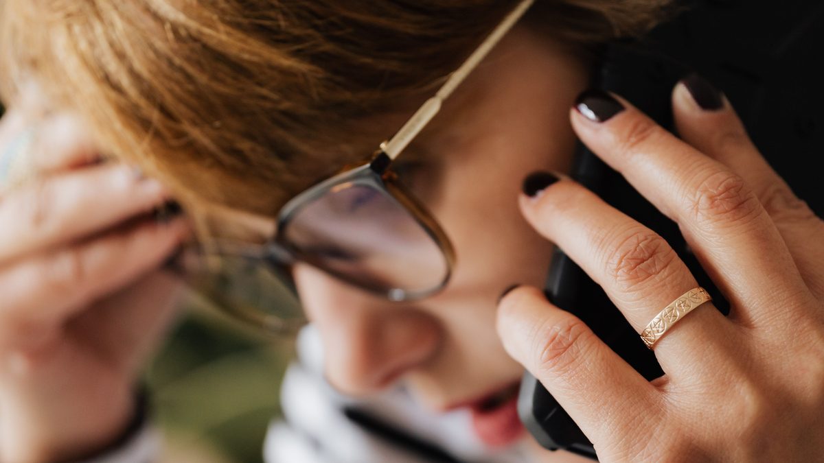 Mulher de óculos preocupada ao telefone