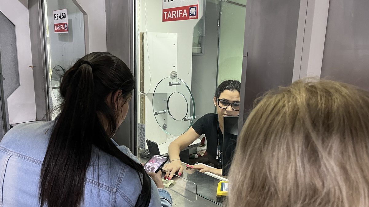 Passageira paga a passagem com o celular na bilheteria da Trensurb, em Porto Alegre, no teste de pagamento por Pix em 2023