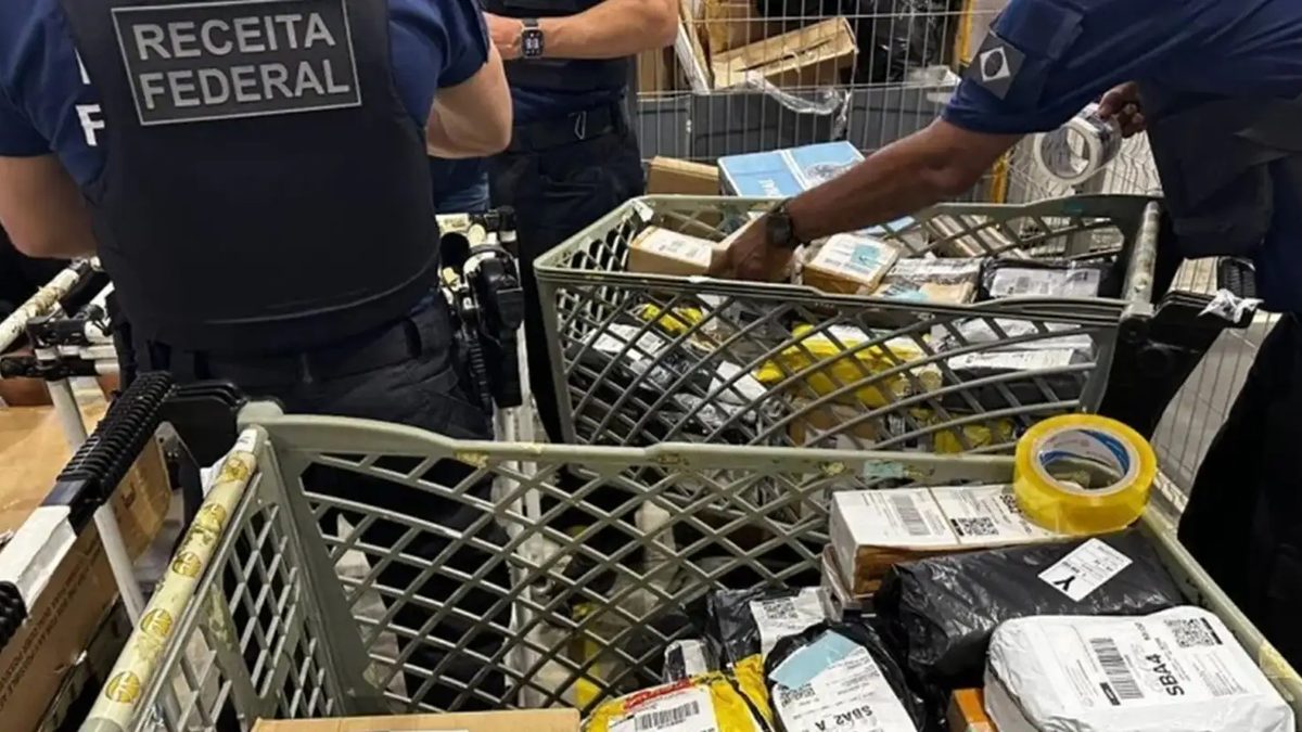 Agentes da Receita Federal de colete conferem encomendas em carrinhos de armazém, em foto de arquivo de operação anticontrabando de março de 2026