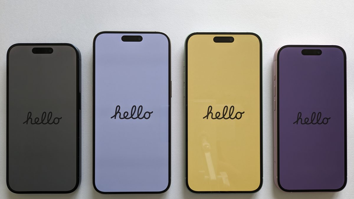 Quatro celulares lado a lado sobre uma mesa branca, cada um com uma cor de tela diferente
